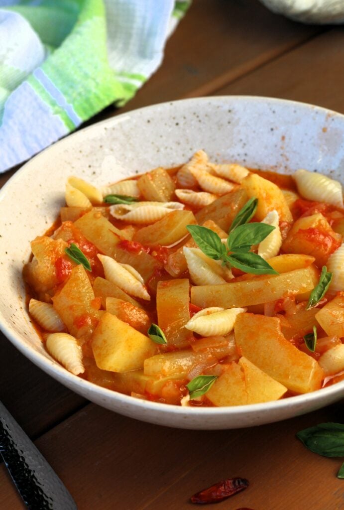 Sicilian cucuzza soup with tomatoes and potatoes in bowl.