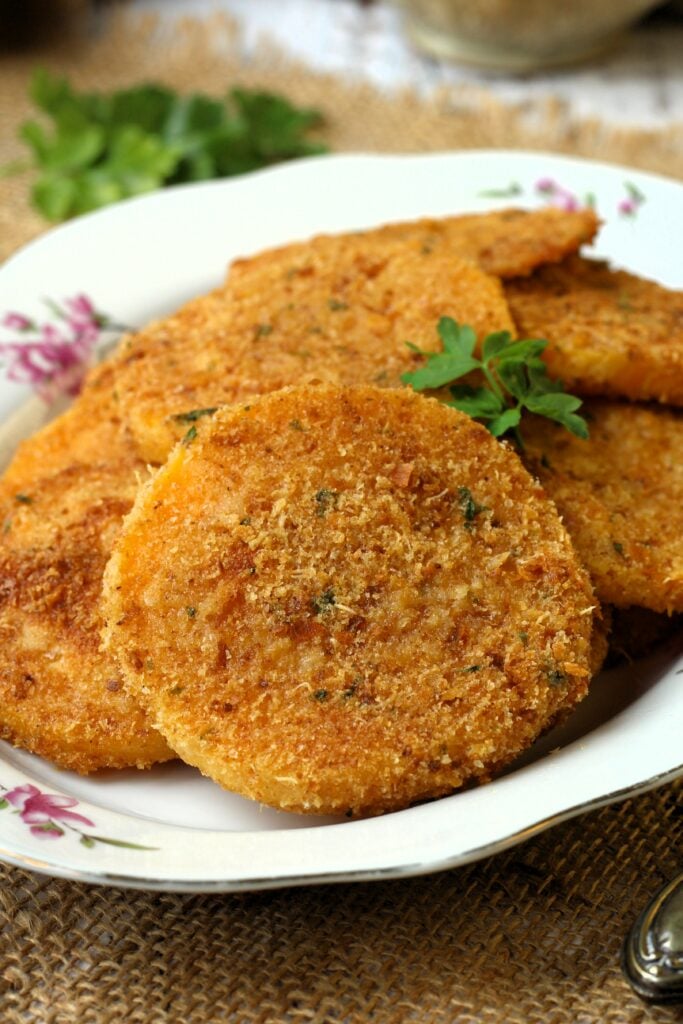 Breaded baked butternut squash cutlets on plate.