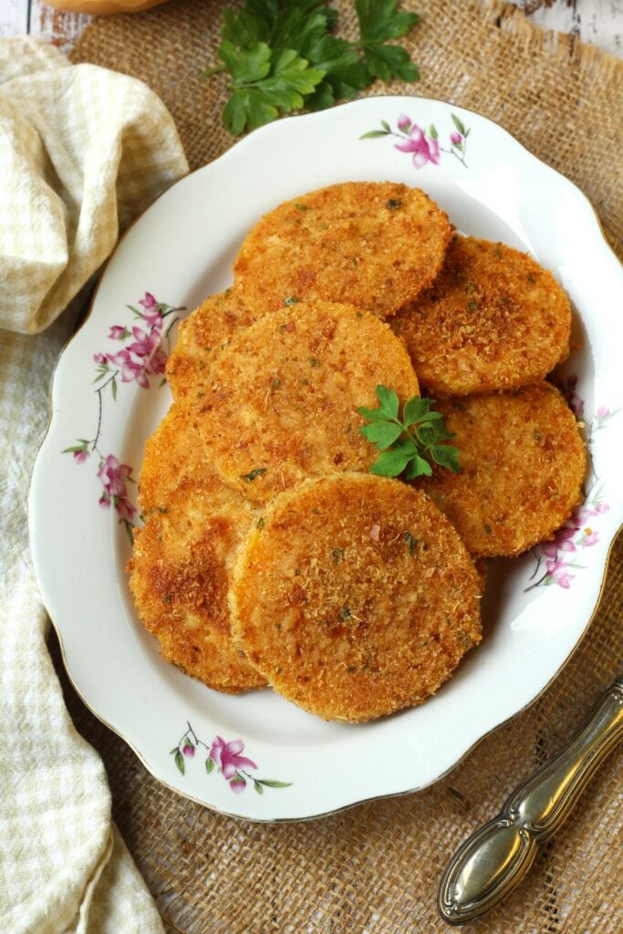 Oven fried breaded butternut squash cutlets on plate.