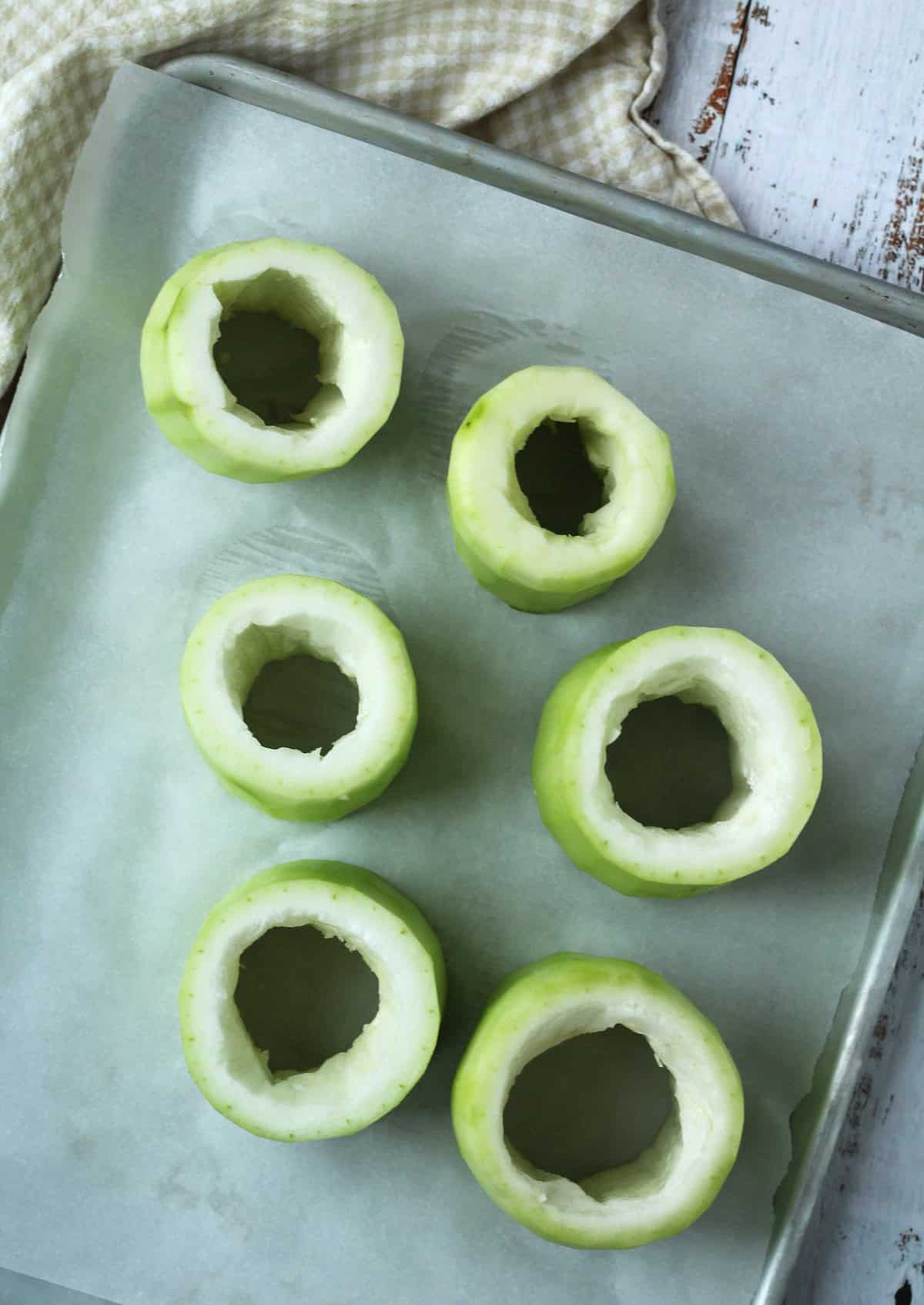 Hollowed out cucuzza squash rounds on baking sheet.