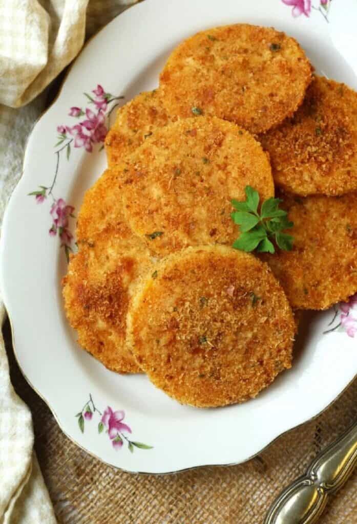 Baked butternut squash cutlets piled on serving plate.