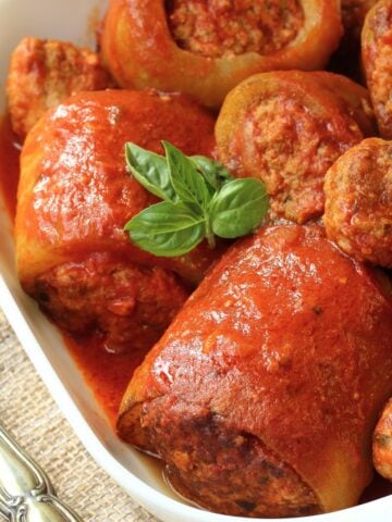 Sicilian stuffed cucuzza on platter topped with basil.