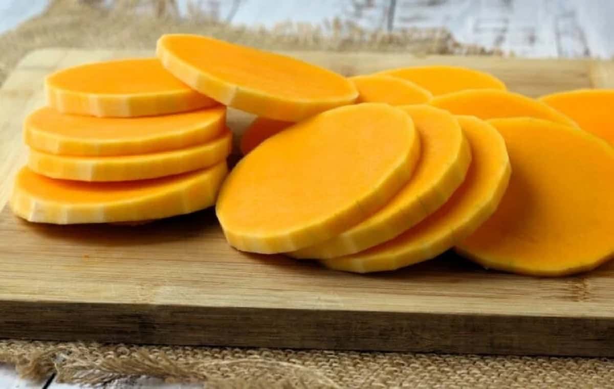 Sliced butternut squash rounds on wood board.