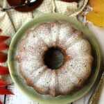 Italian Squash Cake on plate surrounded by coffee cups and leaves.