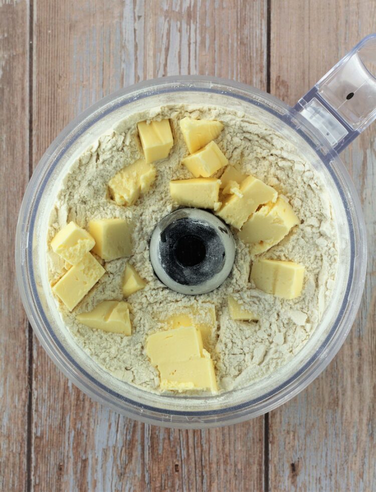 Butter added to flour in food processor bowl.
