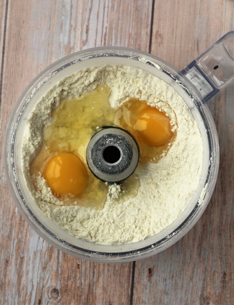 Eggs added to flour in food processor dough.