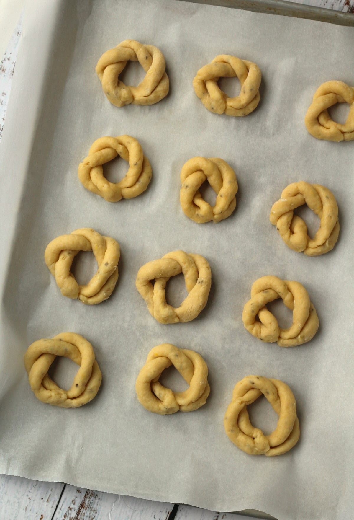 Unbaked lemon anise taralli cookies resting on baking sheet.