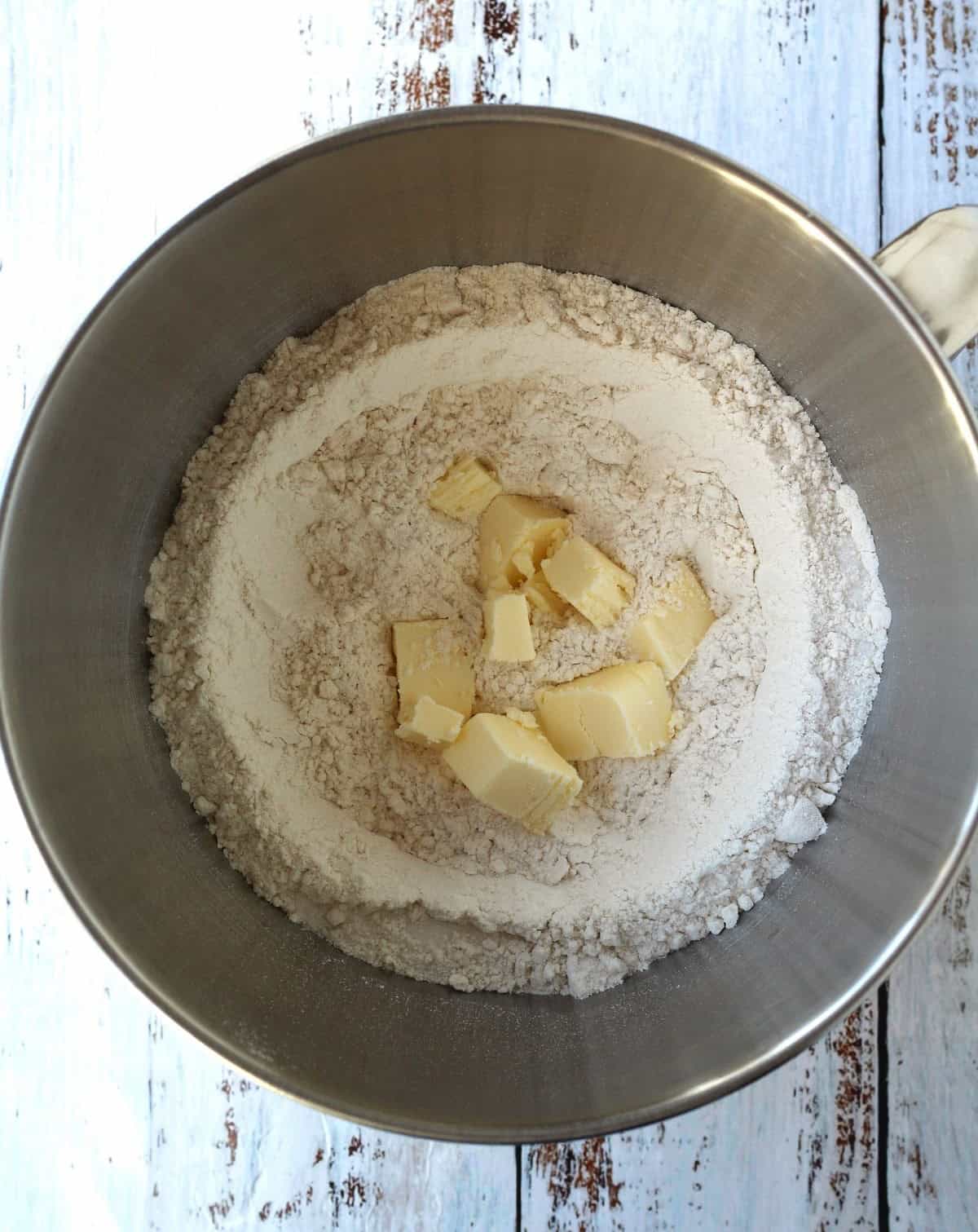 Cubed butter added to flour in food processor bowl for brioche dough.