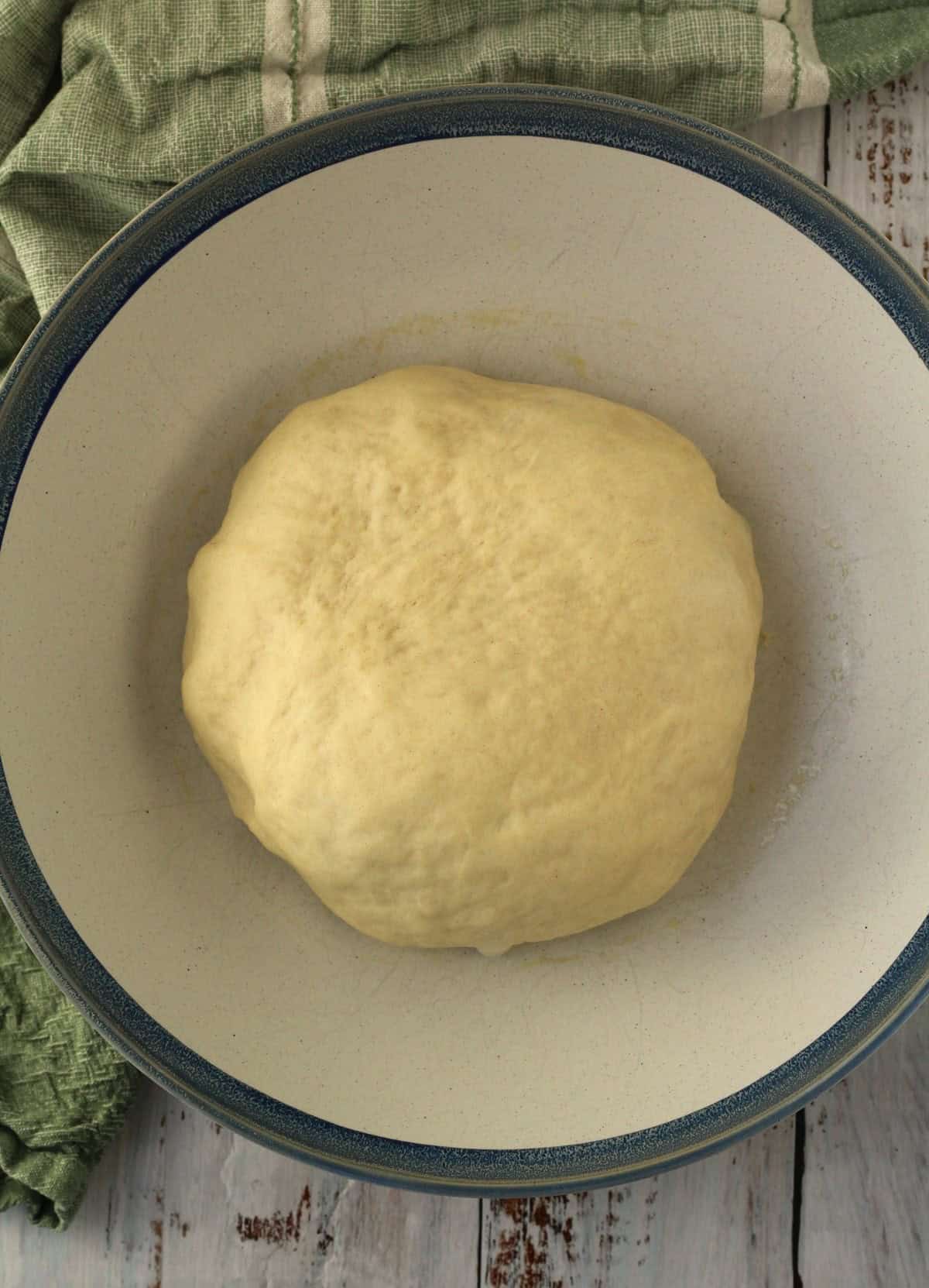 Proofed brioche dough for ravazzate in large bowl.