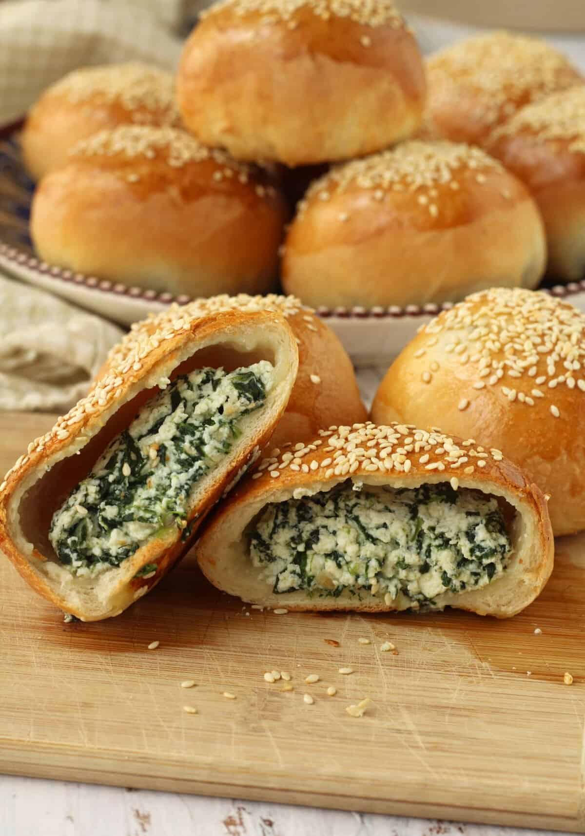 Spinach and ricotta filled ravazzate cut open on wood board.