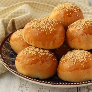 Spinach and ricotta brioche buns (ravazzate) piled on plate.