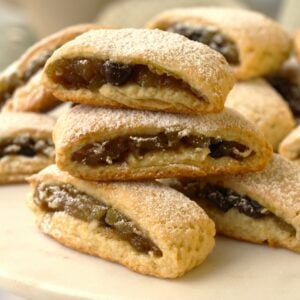 Sicilian cuccidati cookies with zuccata cucuzza jam filling on plate.