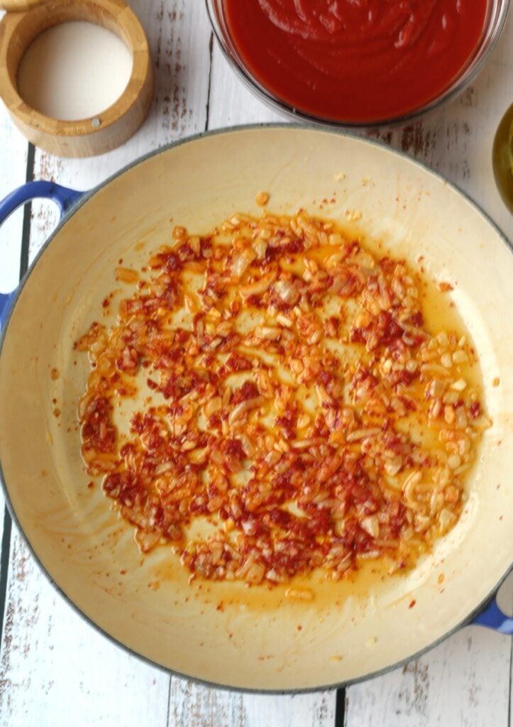 Skillet with sautéed onion, garlic and tomato paste.