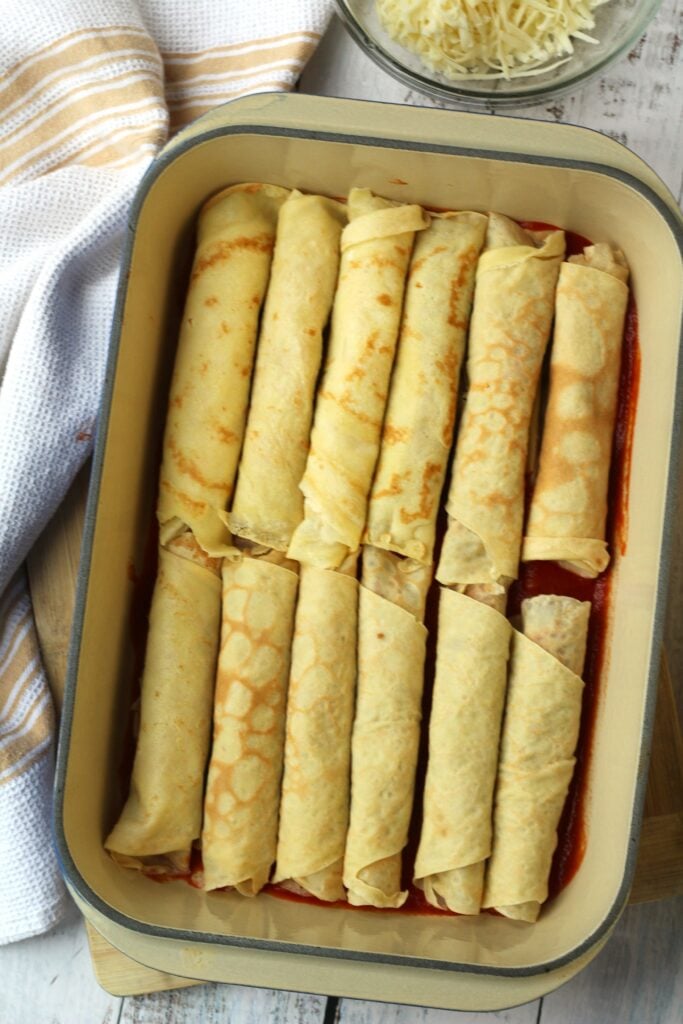 Filled Italian crepes in baking dish.