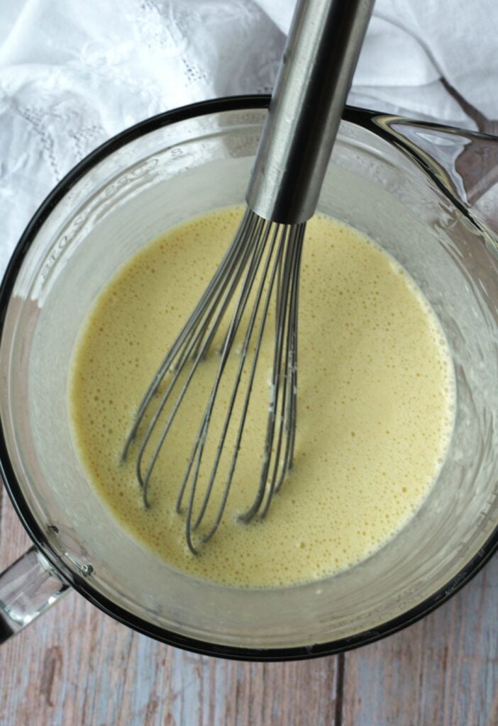 Whisk in measuring cup with milk, flour and eggs.