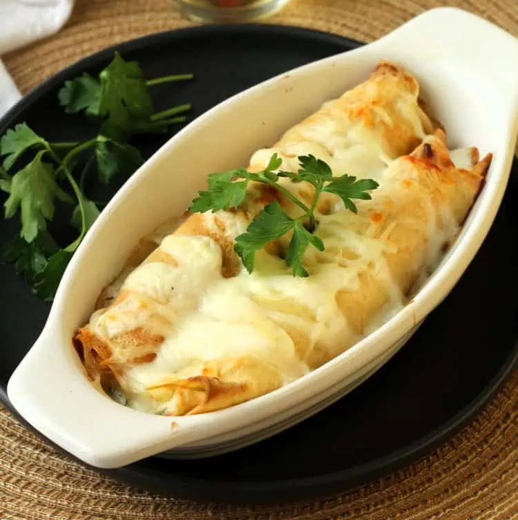 Seafood crepes with béchamel sauce in au gratin dish.