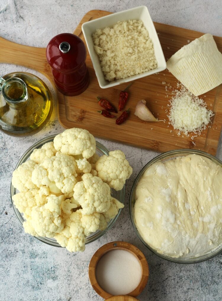 Bowl of pizza dough, cauliflower, fresh breadcrumbs, ricotta salata, salt, pepper and olive oil.