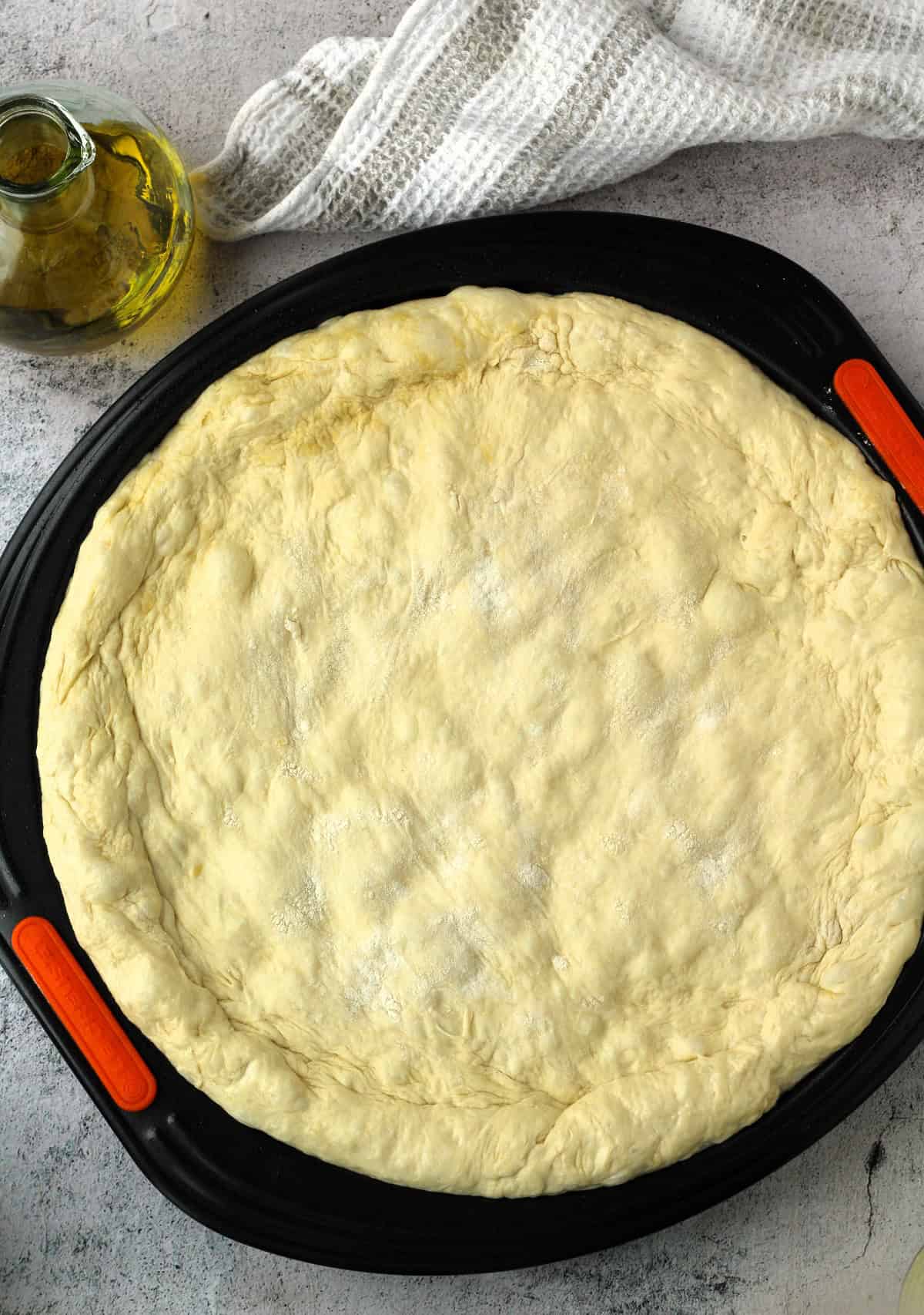 Round no knead pizza dough on pizza pan.