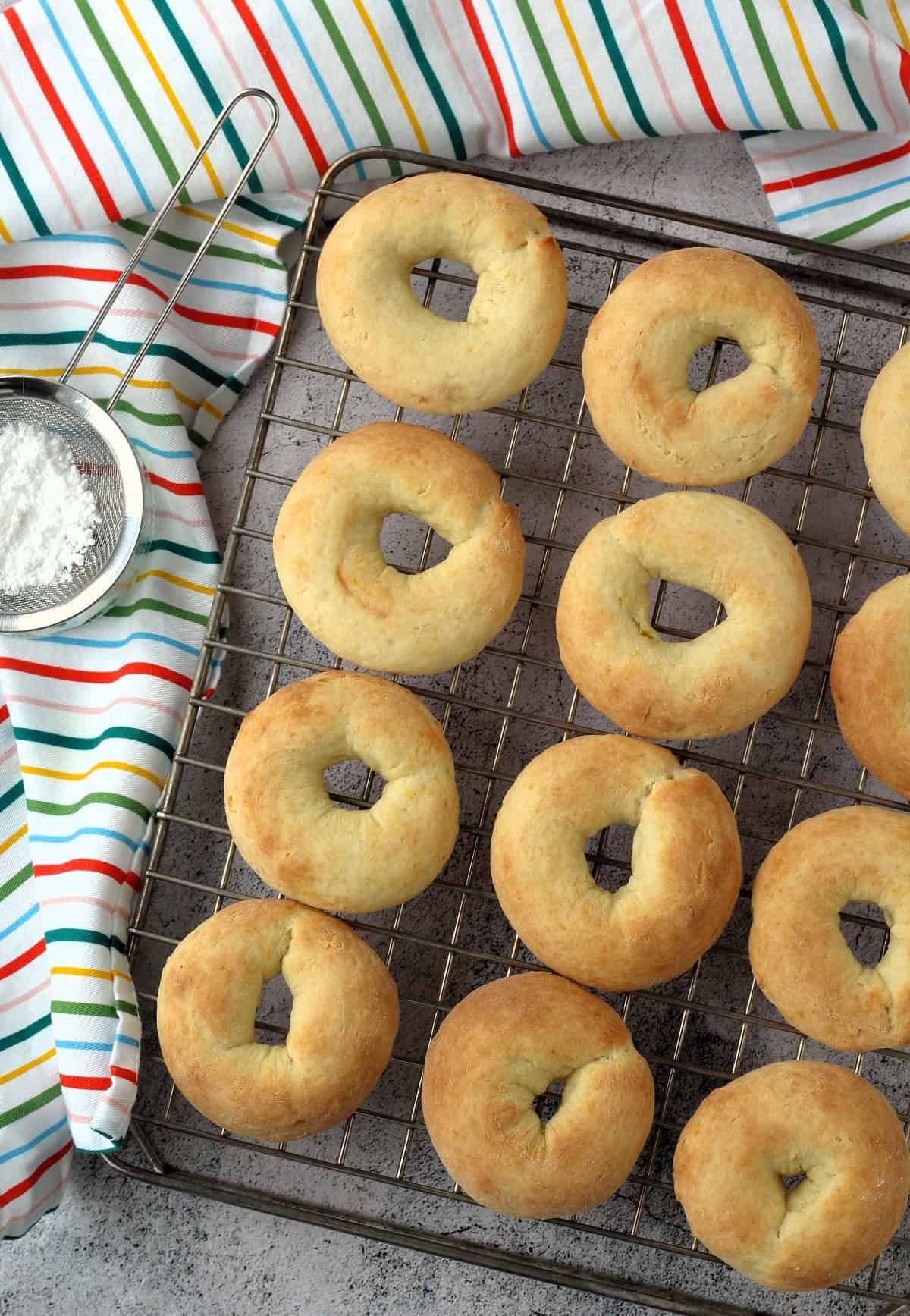 Ciambelline di ricotta ring cookies on wire rack cooling.