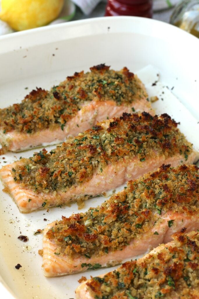 Breaded salmon with lemon garlic in baking dish.