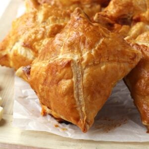 Cipolline Catanesi, or Sicilian onion puff pastry tart on wood board.