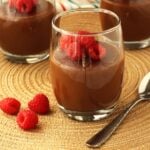 Glasses of chocolate almond milk pudding, or biancomangiare al cioccolato, topped with berries.