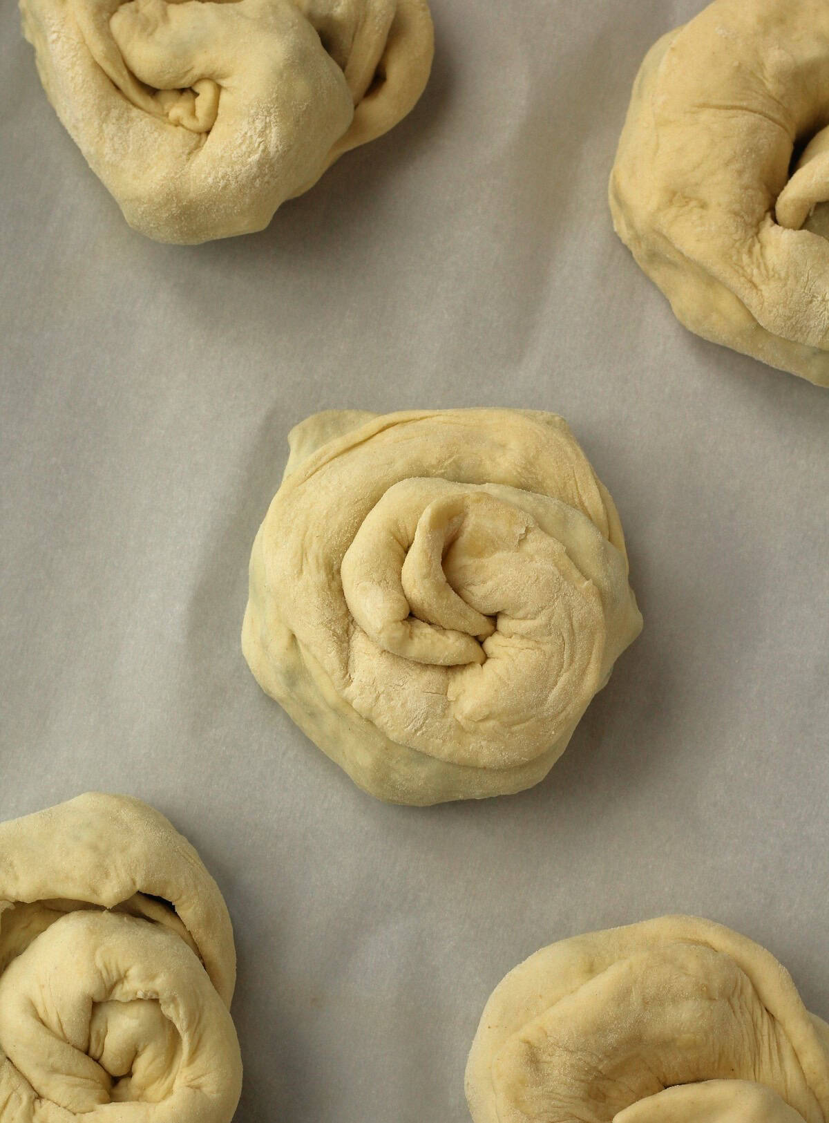 Unbaked Sicilian bignolati rolls on baking sheet.