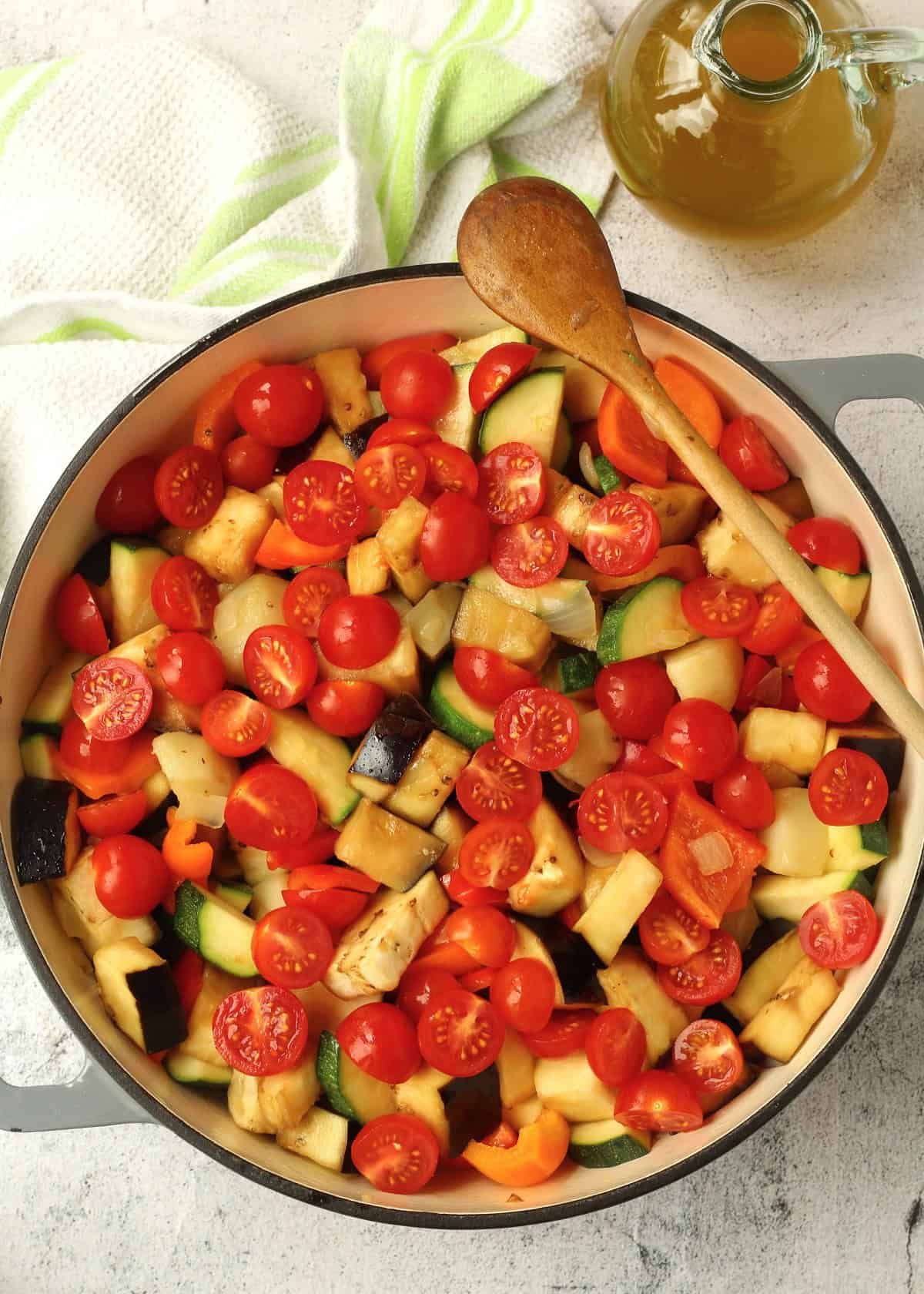 Cherry tomatoes added to skillet with Sicilian summer vegetable stew.