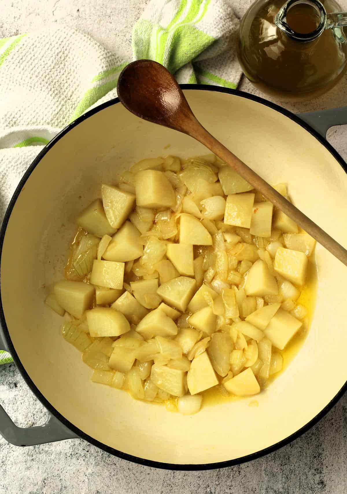 Cubed potatoes added to skillet with sautéed diced onions.