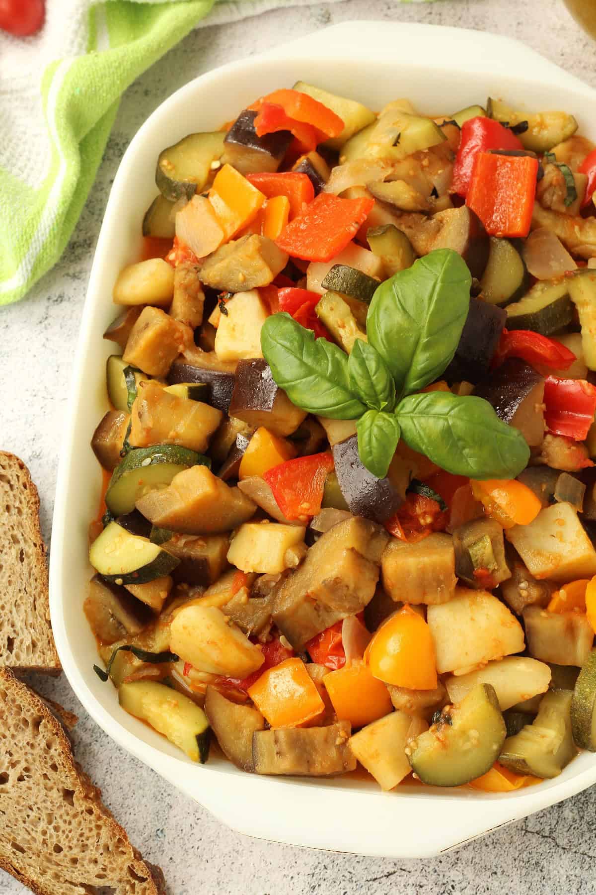 Sicilian stewed vegetable stew (canazzo) in baking dish topped with fresh basil.