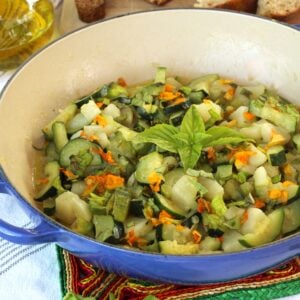 Skillet with sautéed zucchini flowers, zucchini and potatoes.