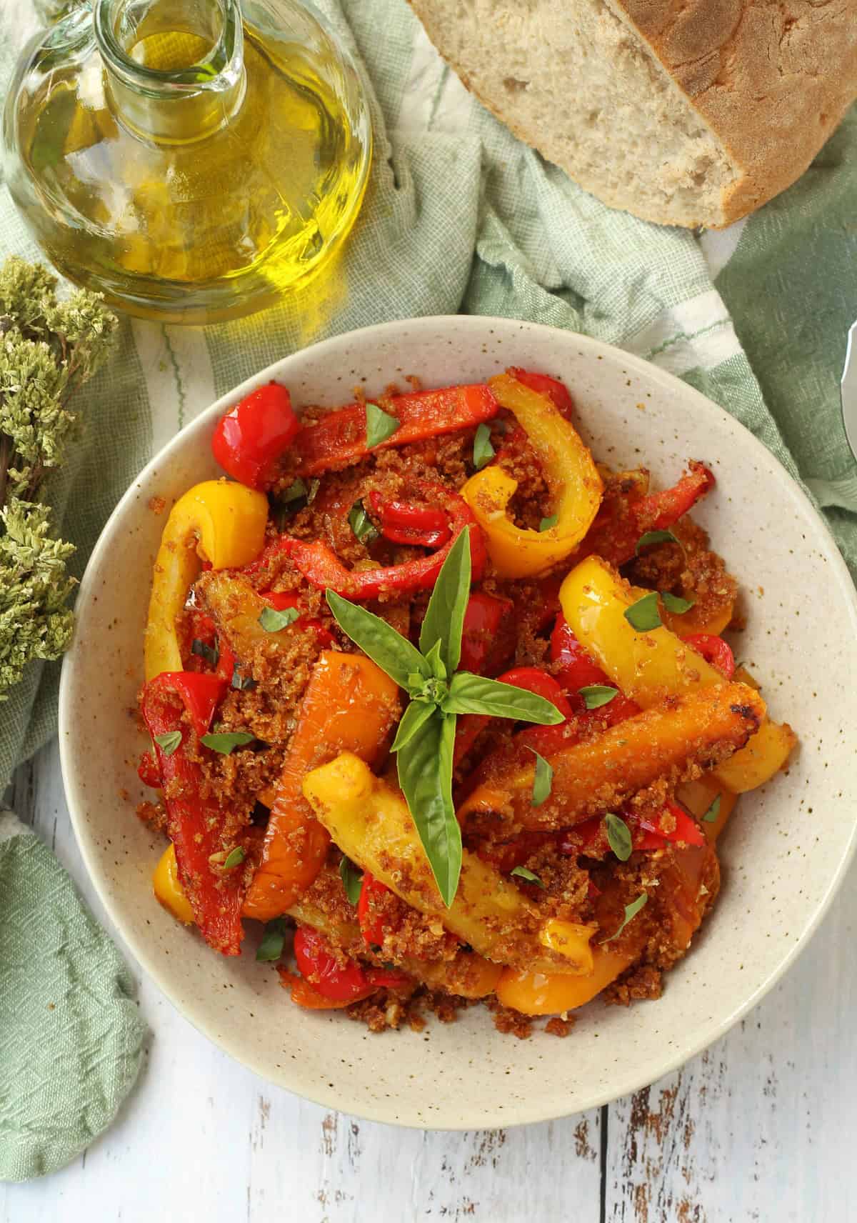 Sicilian peppers with breadcrumbs in bowl topped with basil.