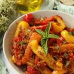 Sicilian peppers with breadcrumbs topped with basil in bowl.