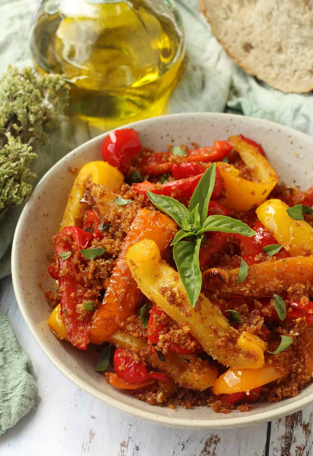 Sicilian peppers with breadcrumbs topped with basil in bowl.