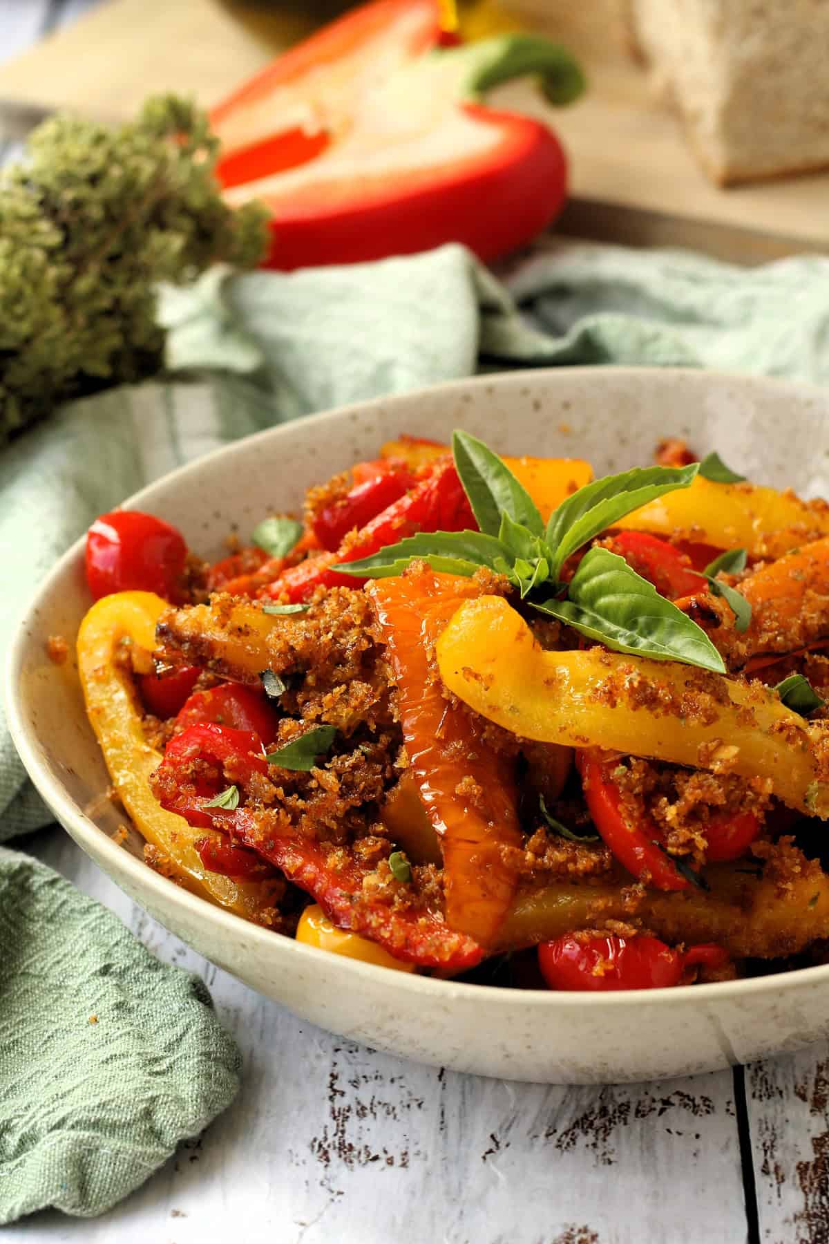 Peperoni ammollicati (peppers with breadcrumbs) in a bowl topped with basil.