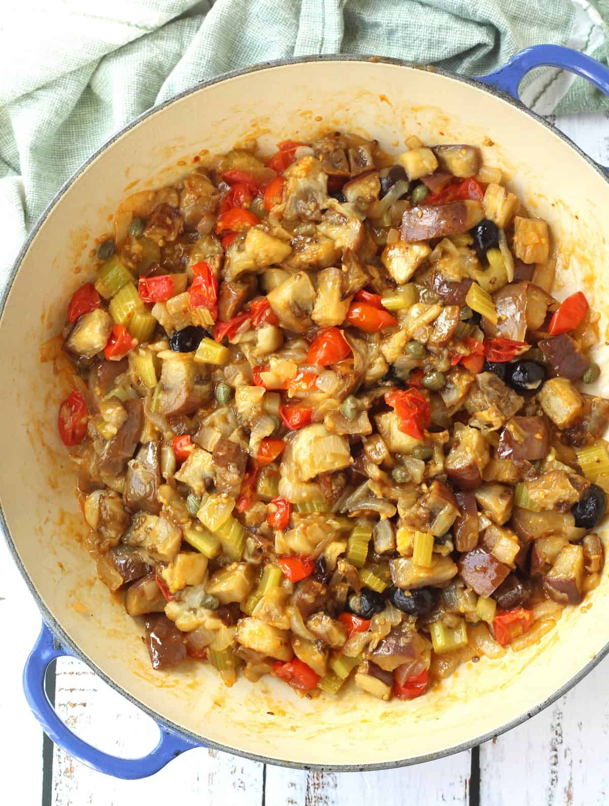 Eggplant caponata in large blue skillet.