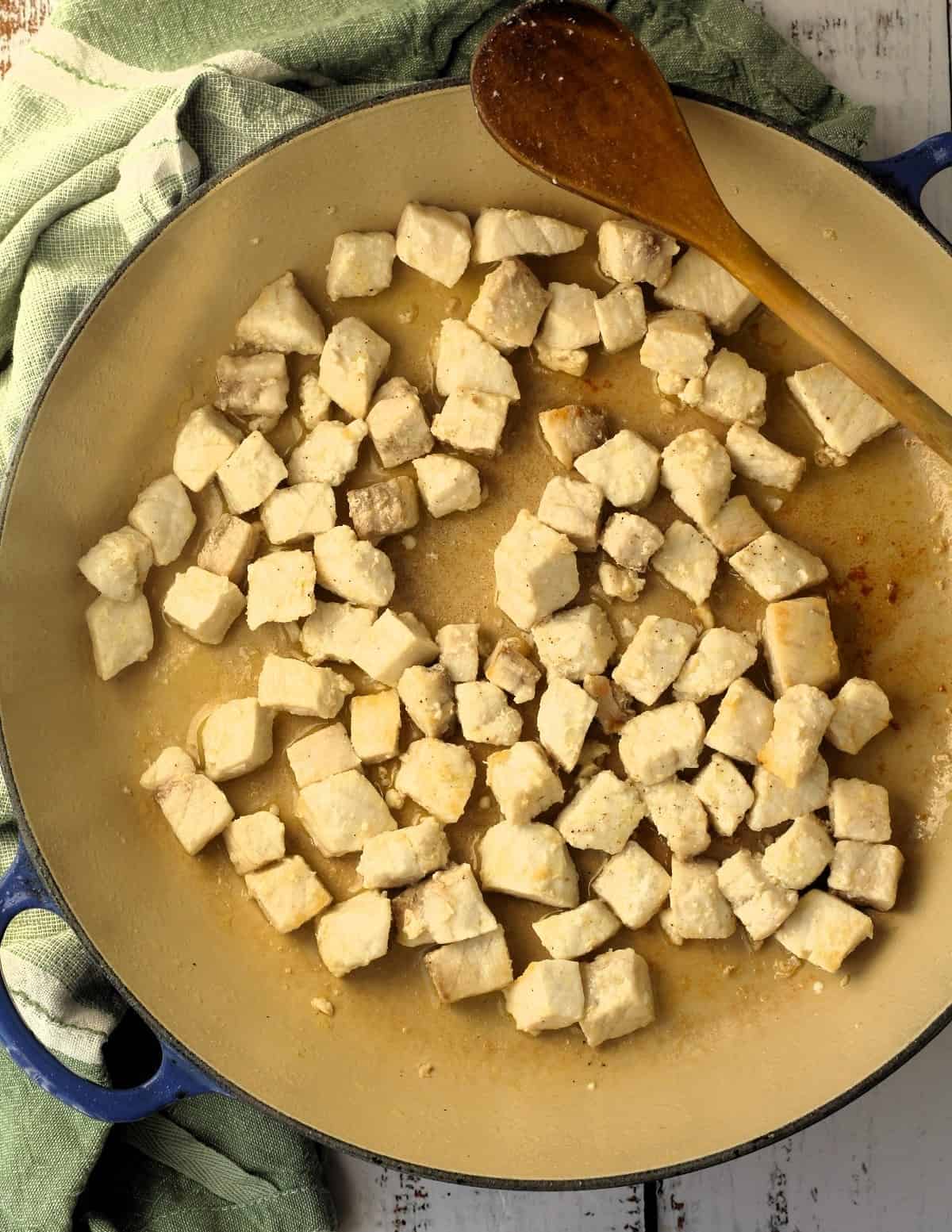 Cubed swordfish in skillet for swordfish caponata recipe.