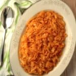 Sicilian sweet and sour cabbage served on oval white plate with spoon on side.