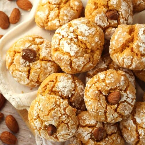 Soft pumpkin cookies with almonds on plate.