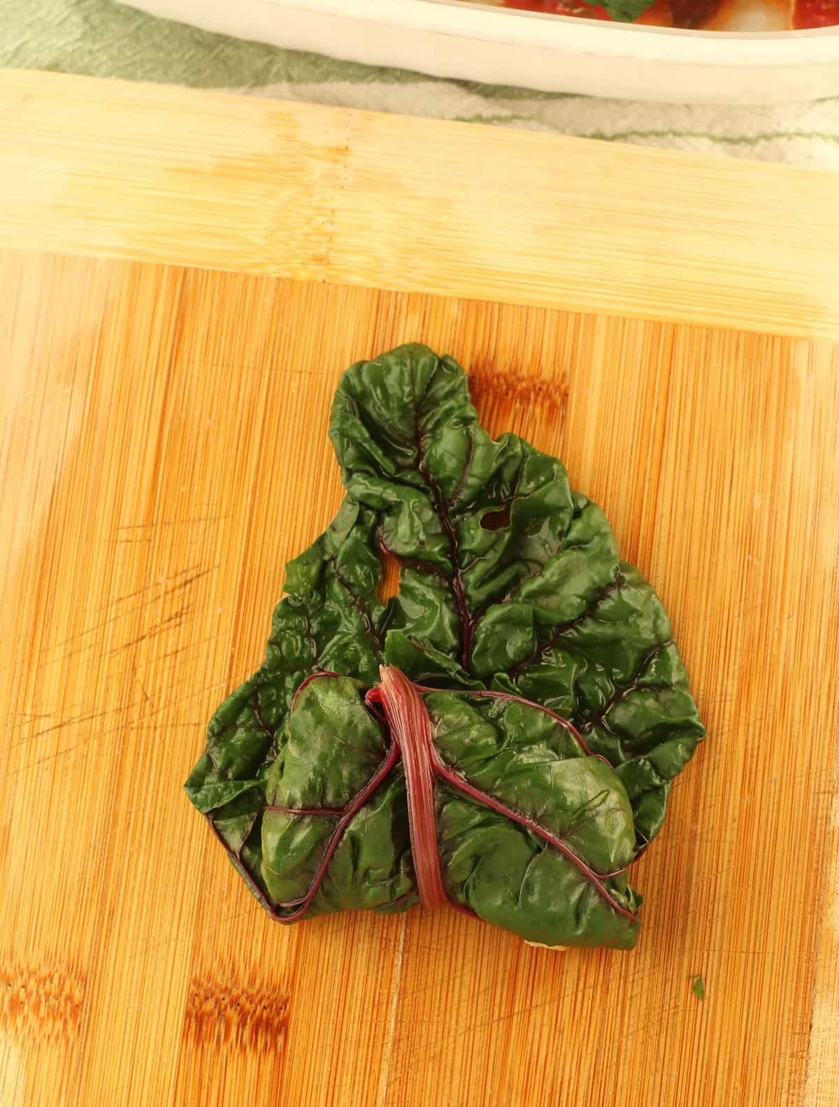 Swiss chard leaf rolled around lentil and rice filling.