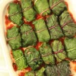 Lentil and rice stuffed swiss chard rolls on baking casserole.