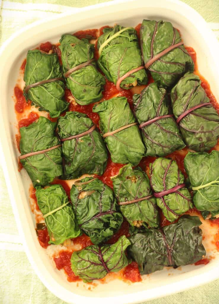 Lentil and rice stuffed swiss chard rolls on baking casserole.