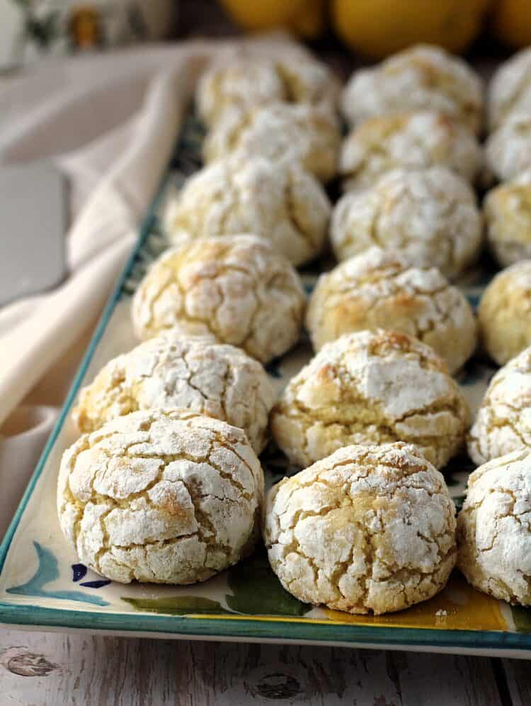 Lemon almond cookies layered on rectangular serving dish.