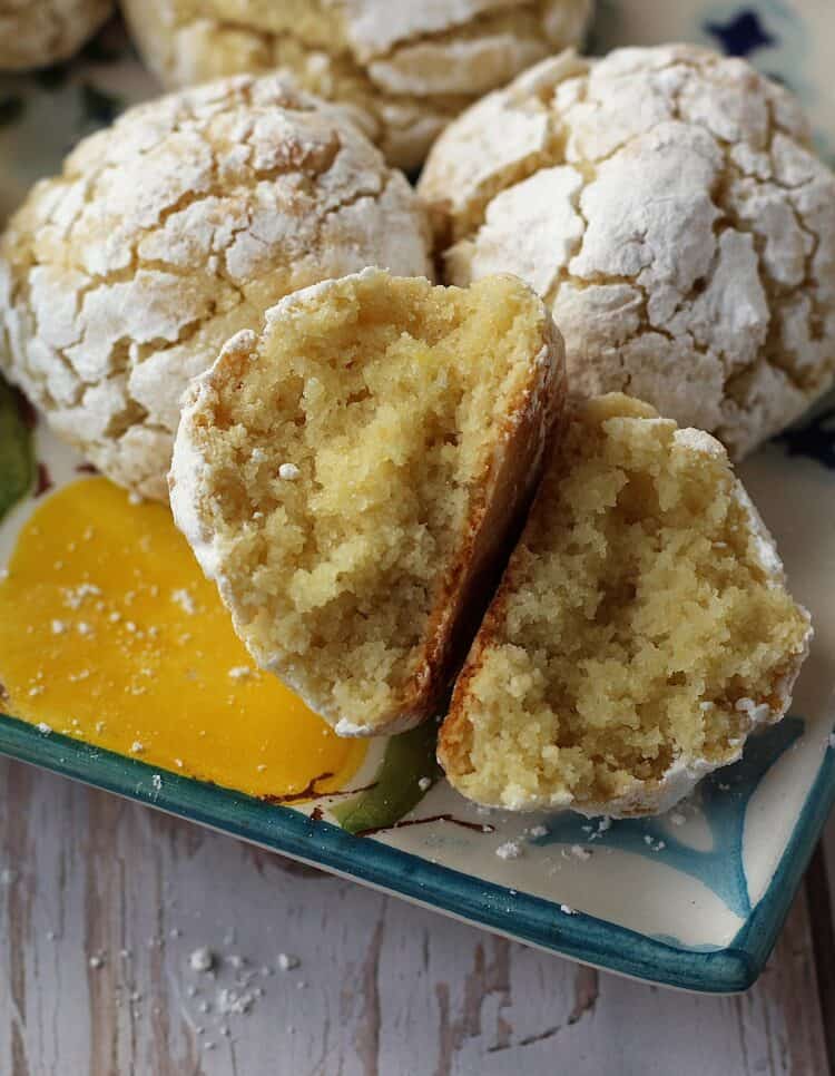 Cut open lemon almond cookie on cookie platter with other cookies.