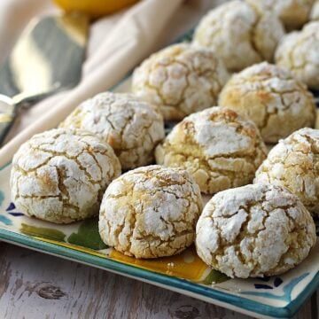 Crinkle lemon almond cookies on rectangular plate.