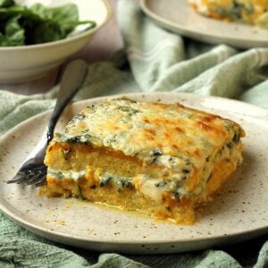 Butternut squash and spinach lasagna on plate with fork.