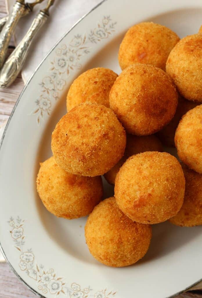 Arancini with ham and cheese (arancini al burro) piled on oval platter.