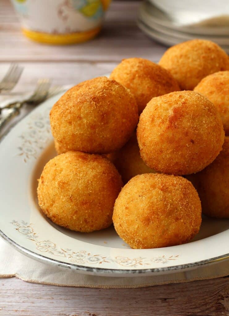 Arancini al burro (arancini with mozzarella) piled on serving plate.