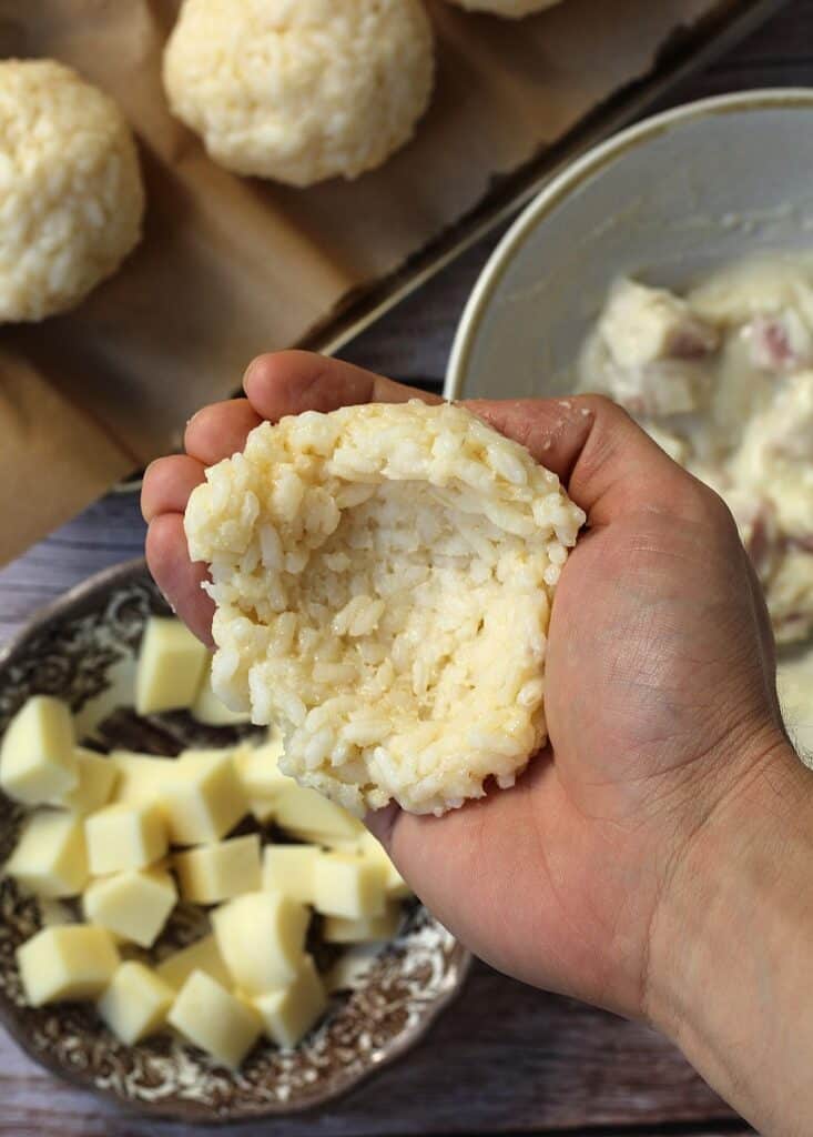Rice flattened in palm of hand to shape arancini.