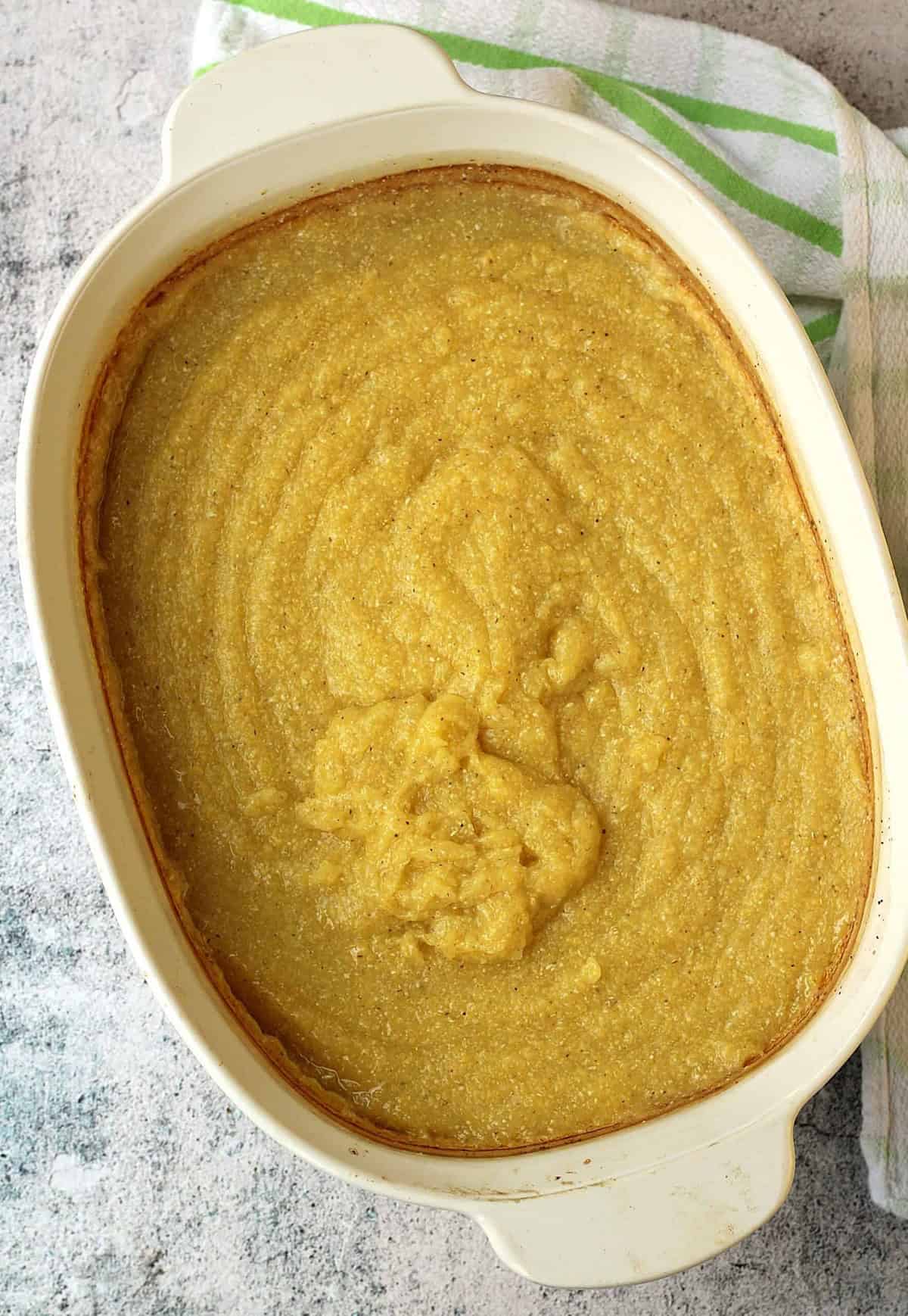 Creamy baked polenta in casserole dish for polenta lasagna recipe.